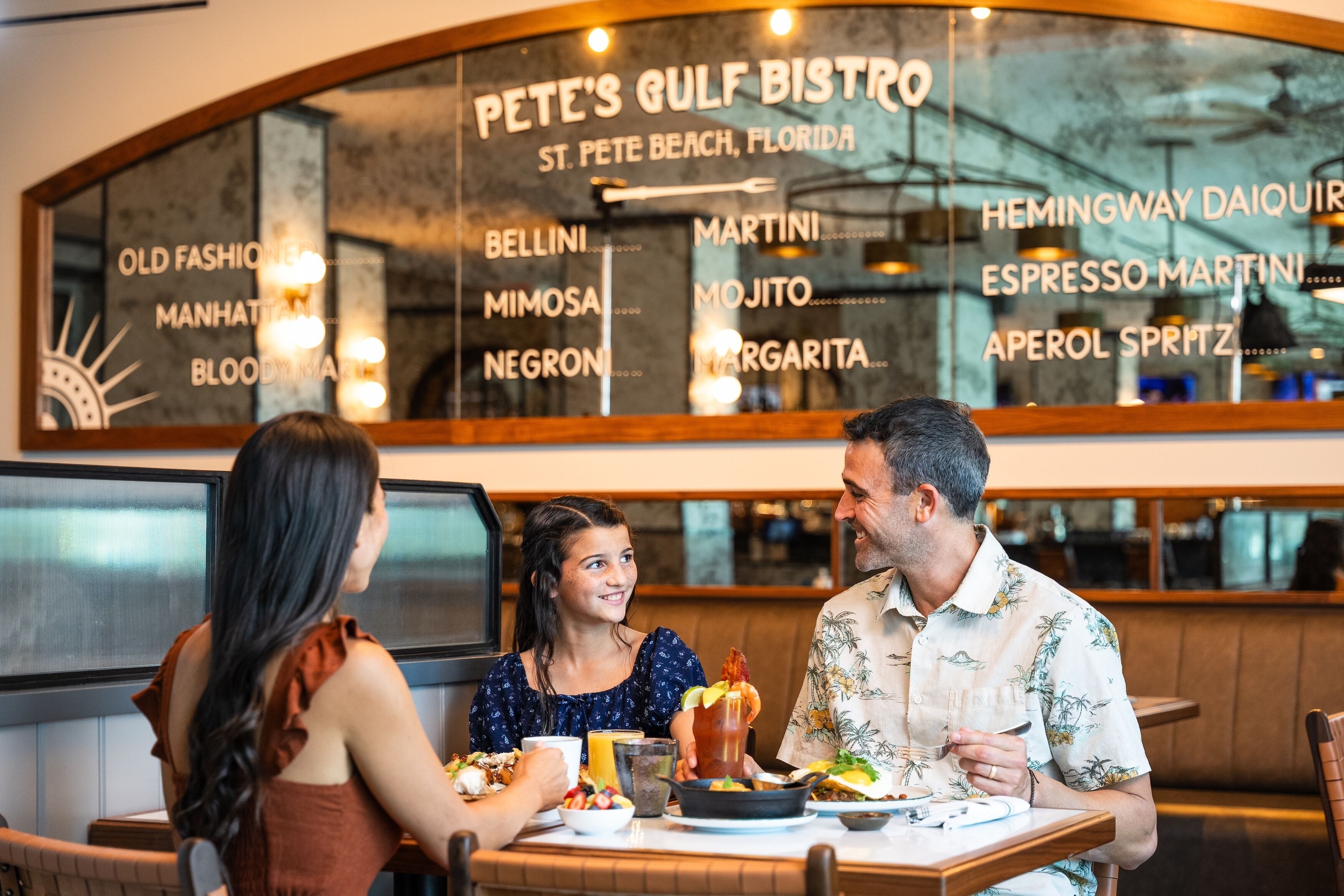 A restaurant with a menu board listing items like Bellini, Martini, and Mojito.