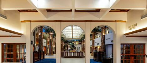 A spacious lobby with high ceilings, wooden beams, and a central reception area.
