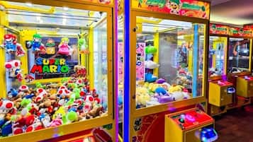 Eine Reihe von hell erleuchteten Krabschere-Automaten, gefüllt mit Stofftieren und beschriftet mit verschiedenen Videospiel-Figuren.