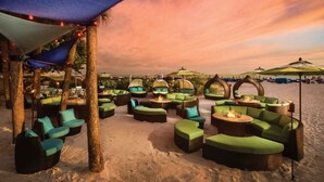 Un salon de plage avec des espaces de détente en plein air et des parasols.