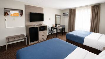 Une chambre d’hôtel avec deux lits, un bureau avec une chaise, une télévision, un minibar et un appareil de climatisation.