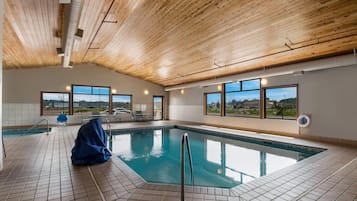 Una piscina techada, sillones reclinables de piscina