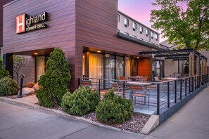 A modern building with a sign reading 'Highland Corner Grill.'