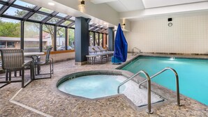 A pool area with a hot tub, seating, and a view through large windows. - Best Western Plus InnTowner Madison (Madison)