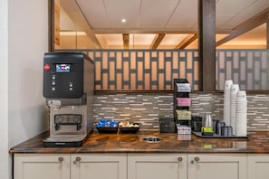 A coffee station with a coffee machine, sugar, creamer, and napkins.