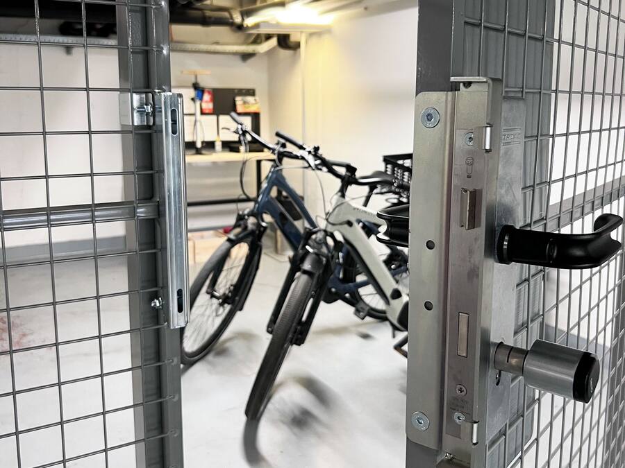 A metal gate with a bicycle rack inside a garage.