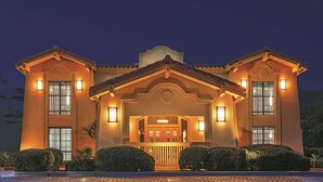 A two-story building with a symmetrical facade, large windows, and a central entrance with a balcony. - La Quinta Inn by Wyndham Midland (Midland)