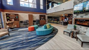 A spacious lobby with a large seating area, a fireplace, and a bar.