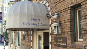 The entrance of Hotel Beresford Arms with a classic brick facade and a large, arched awning. - Beresford Arms Hotel (San Francisco)
