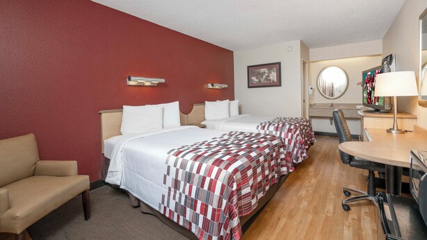 A hotel room with two beds, a desk, a chair, and a television. - Red Roof Inn Chesapeake Conference Center (Chesapeake)