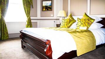 Una cama bien hecha con cabecera de madera, lámpara de noche y almohadas decorativas.