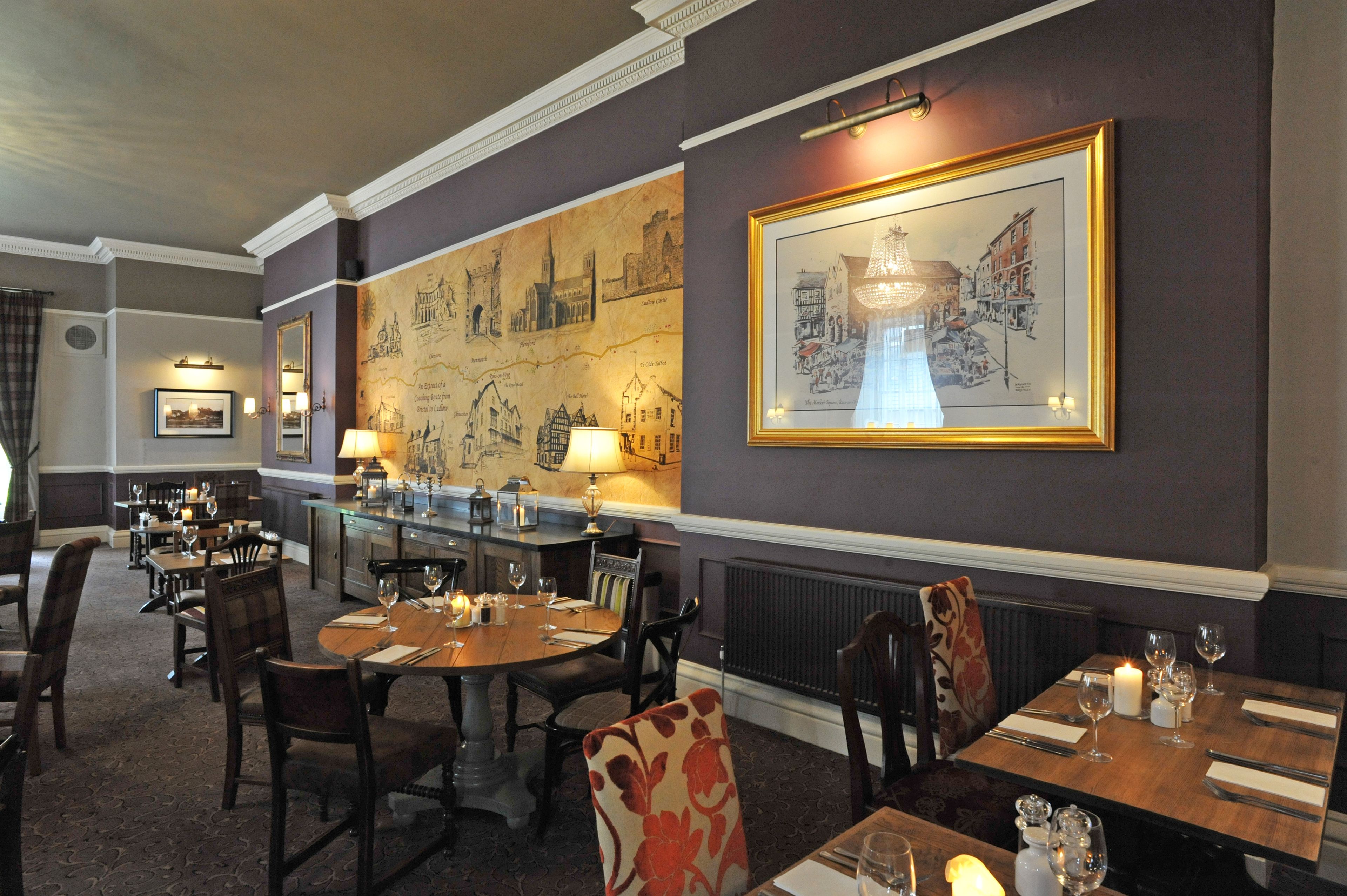 A dining area with tables set for two, featuring dark wood furniture and a carpeted floor.