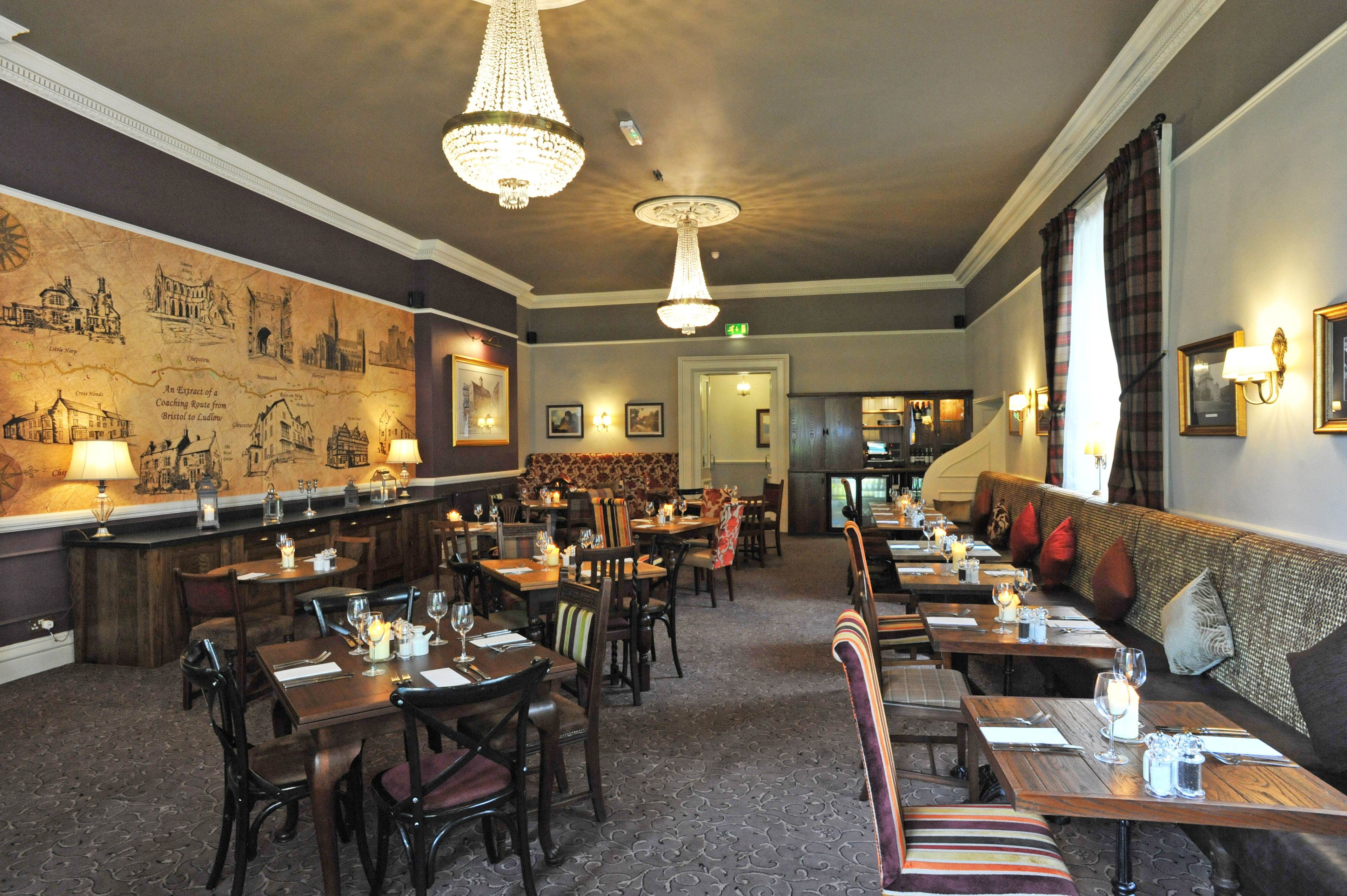 Ein Restaurant mit Holztischen und -stühlen, einer Bar und einem Wandgemälde.