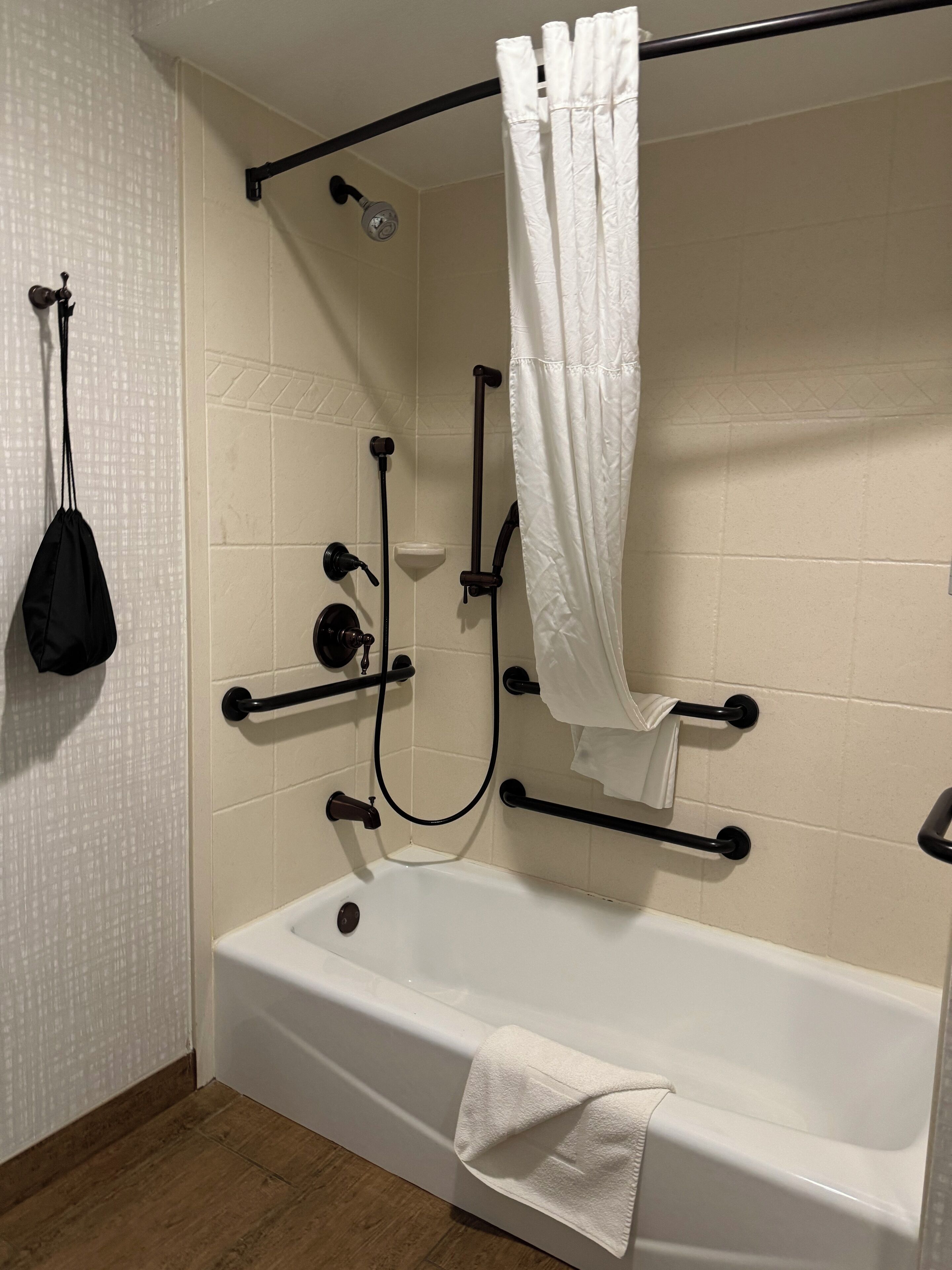 Une salle de bain avec une baignoire, une douche avec un rideau et un porte-serviettes.