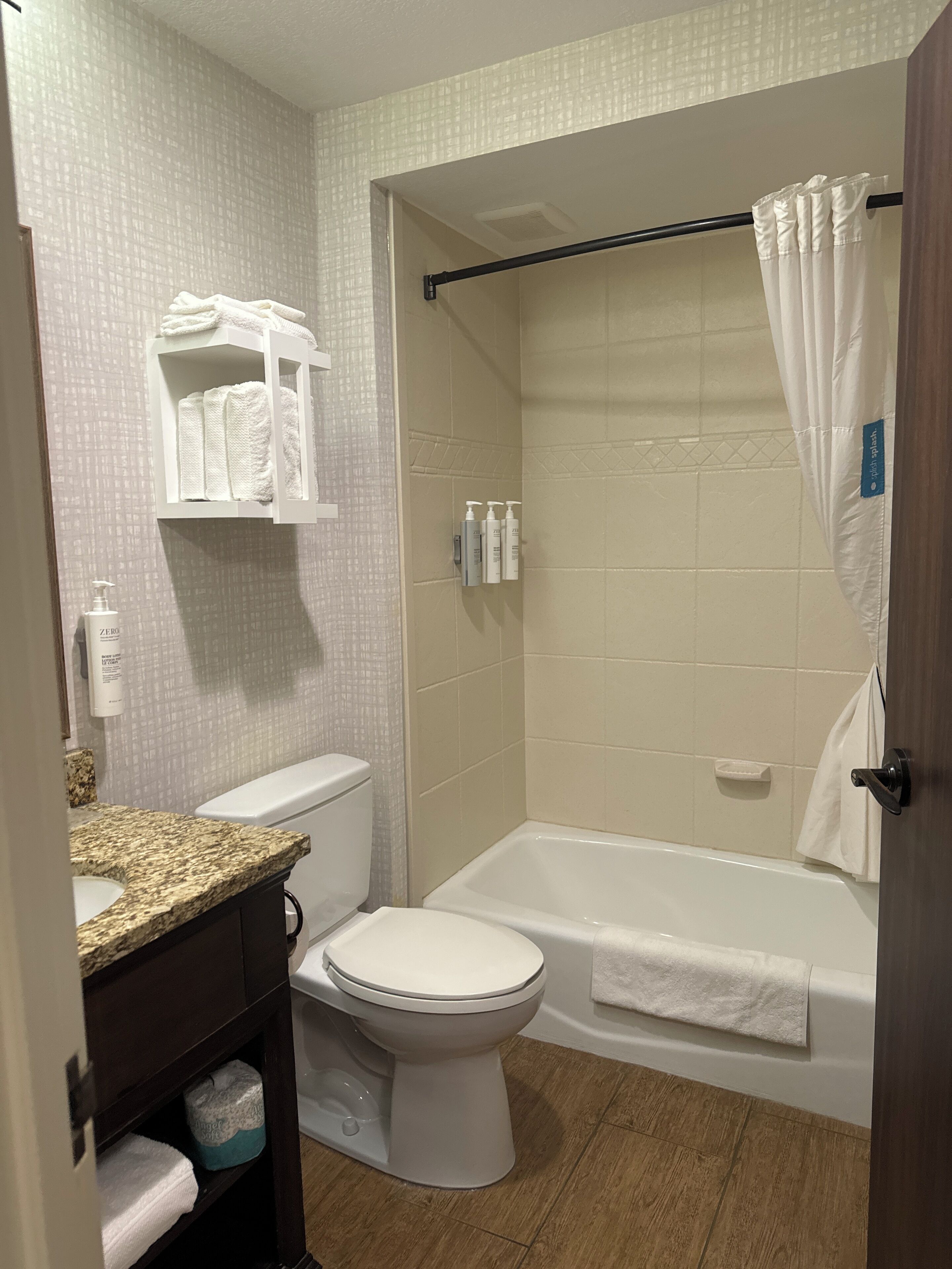 Une salle de bain équipée de toilettes, d’un lavabo et d’une baignoire. On peut voir des serviettes et des articles de toilette.