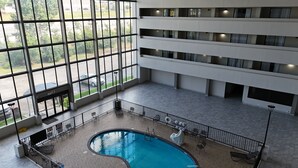 Une piscine intérieure à plusieurs niveaux, avec de grandes fenêtres donnant sur le parking.
