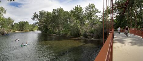 A river with boats and a pedestrian bridge.