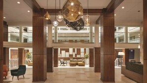 A spacious lobby with high ceilings, a central seating area, and a reception desk. - Embassy Suites by Hilton Richmond (Richmond)