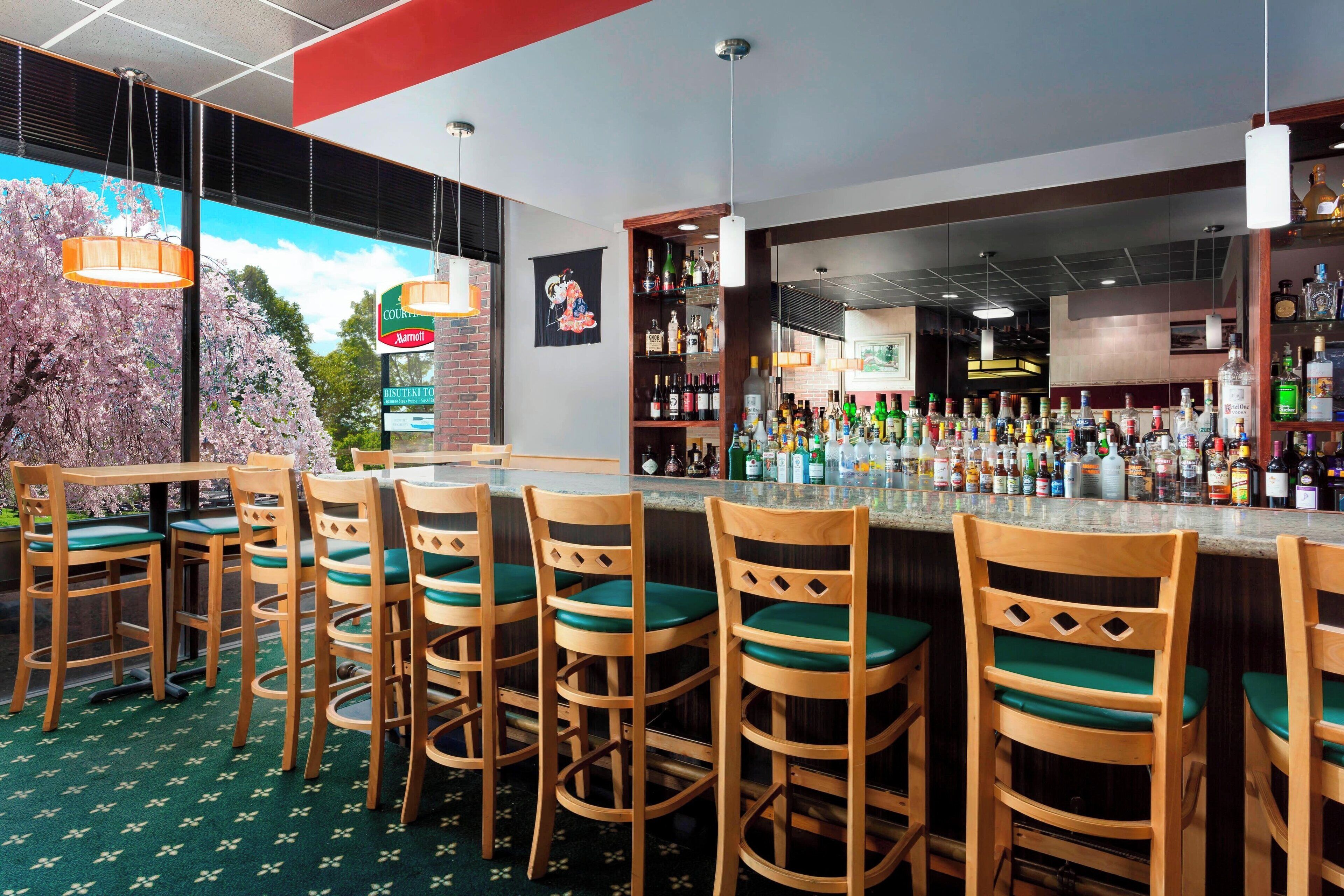 A bar area with wooden chairs and a bar counter stocked with various bottles.
