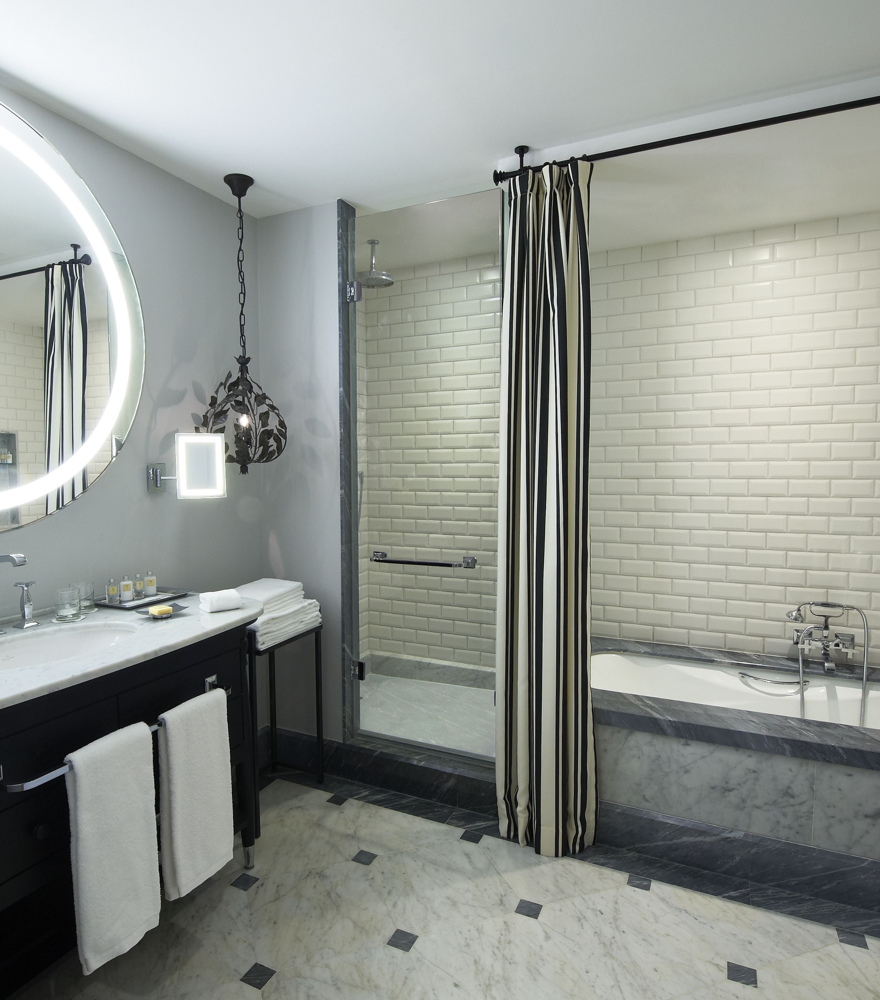 A modern bathroom with a glass-enclosed shower, a vanity with a mirror, and a bathtub.