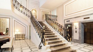 A grand staircase with ornate railings, a marble floor, and a fireplace. - Hotel Maria Cristina, a Luxury Collection Hotel (San Sebastián)