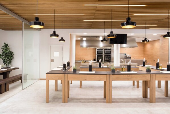 A modern kitchen with wooden cabinets, stainless steel appliances, and pendant lighting.