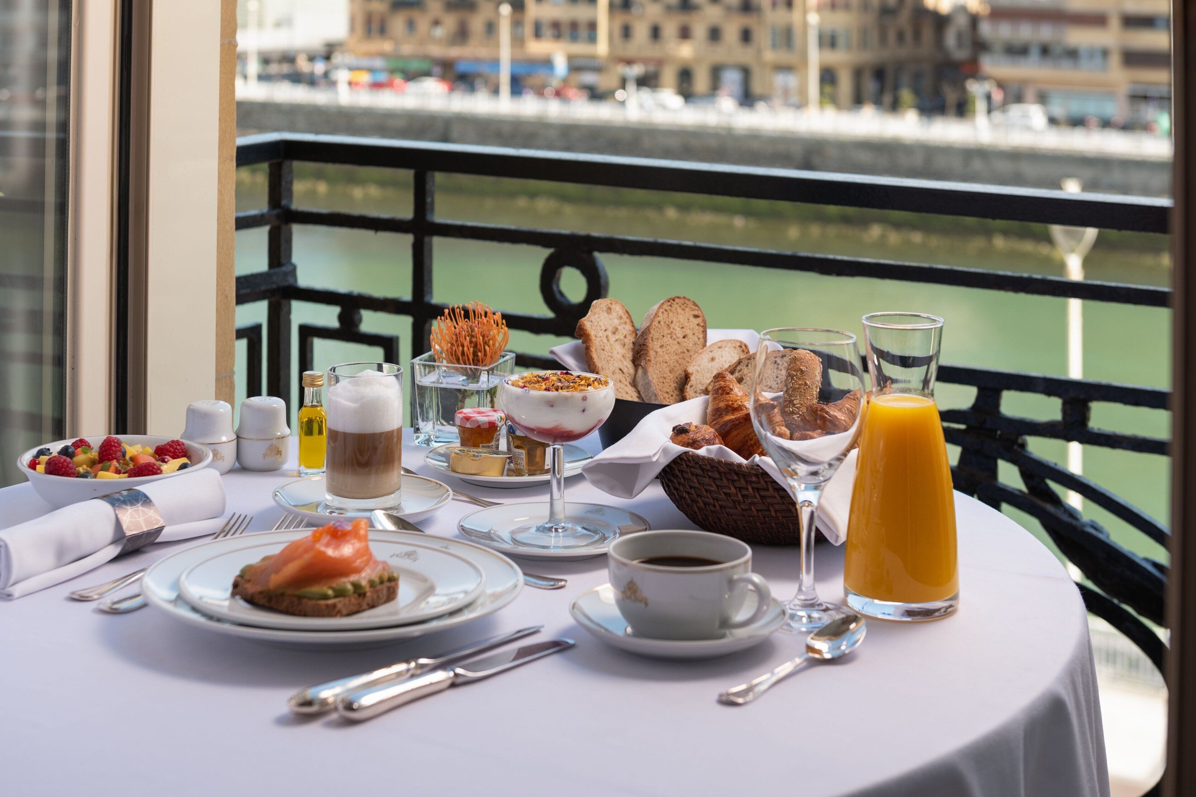 Una mesa de desayuno con diversos platos, bebidas y utensilios.