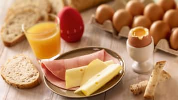 Desayuno con pan, huevos, queso y un vaso de zumo de naranja.