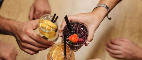 Un grupo de personas sosteniendo bebidas formando un círculo.