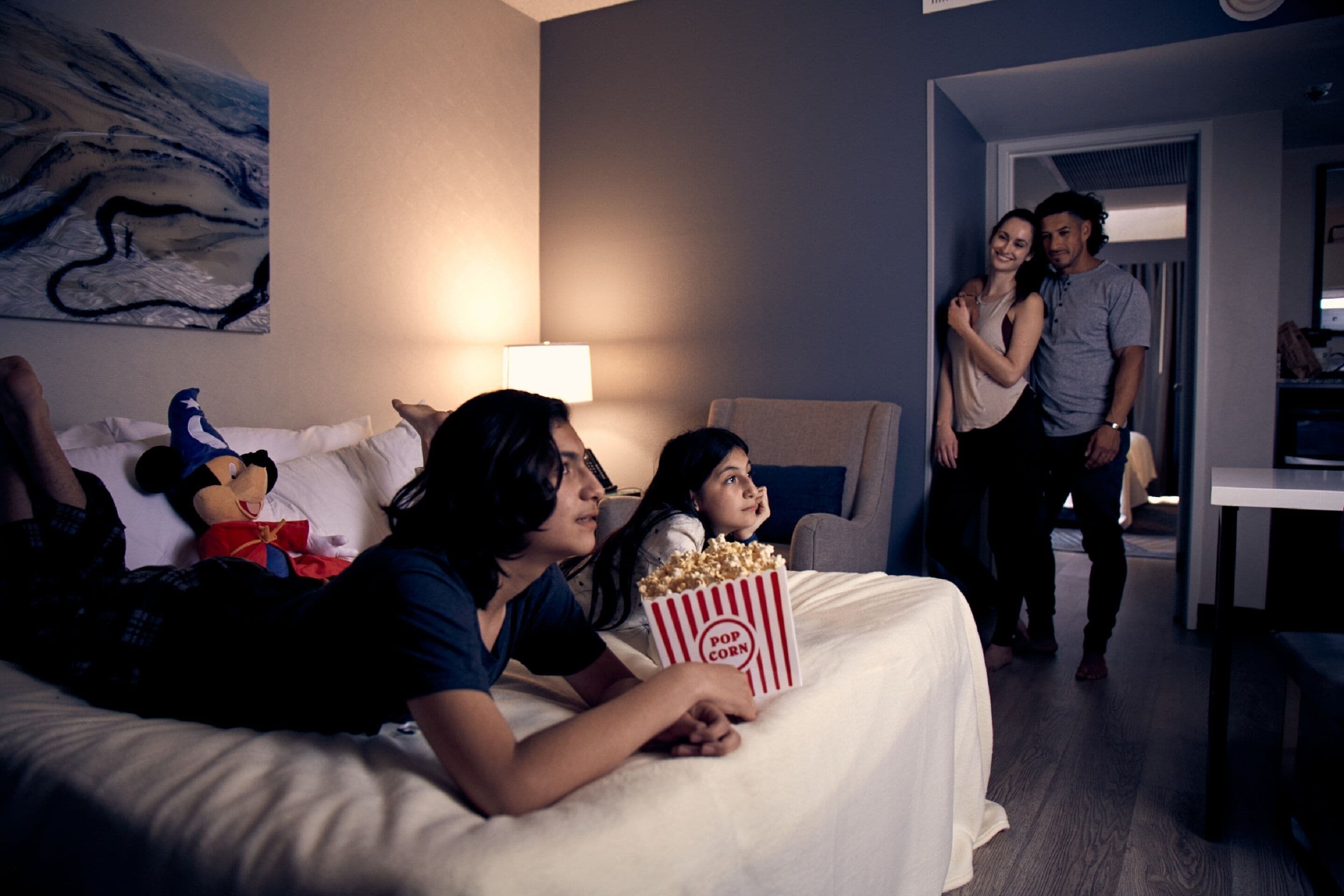 Una habitación con una cama, una lámpara y un cuadro en la pared.