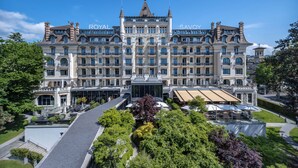 Ein großes, historisches Hotel mit der Aufschrift "ROYAL SAVOY", mit einer prachtvollen Fassade, mehreren Balkonen und einem zentralen Eingang.