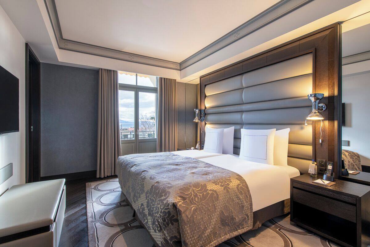 Una habitación de hotel moderna con una cama grande, un escritorio y vistas a la ciudad.