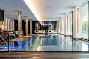 Alberca techada, alberca al aire libre y camastros