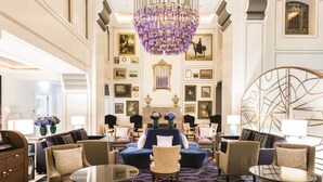 Eine luxuriöse Lobby mit einem prunkvollen Chandelier, komfortablen Sitzmöglichkeiten und einer Kunstgalerie.