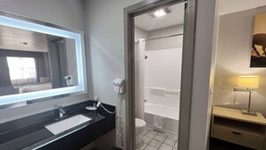 A bathroom with a black sink, a mirror, a toilet, and a shower.