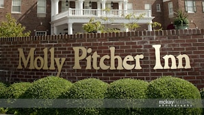 A brick building with a sign reading "Molly Pitcher Inn" and a tower.