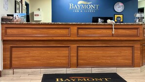 A reception desk with a blue wall and the text "Baymont Inn & Suites".