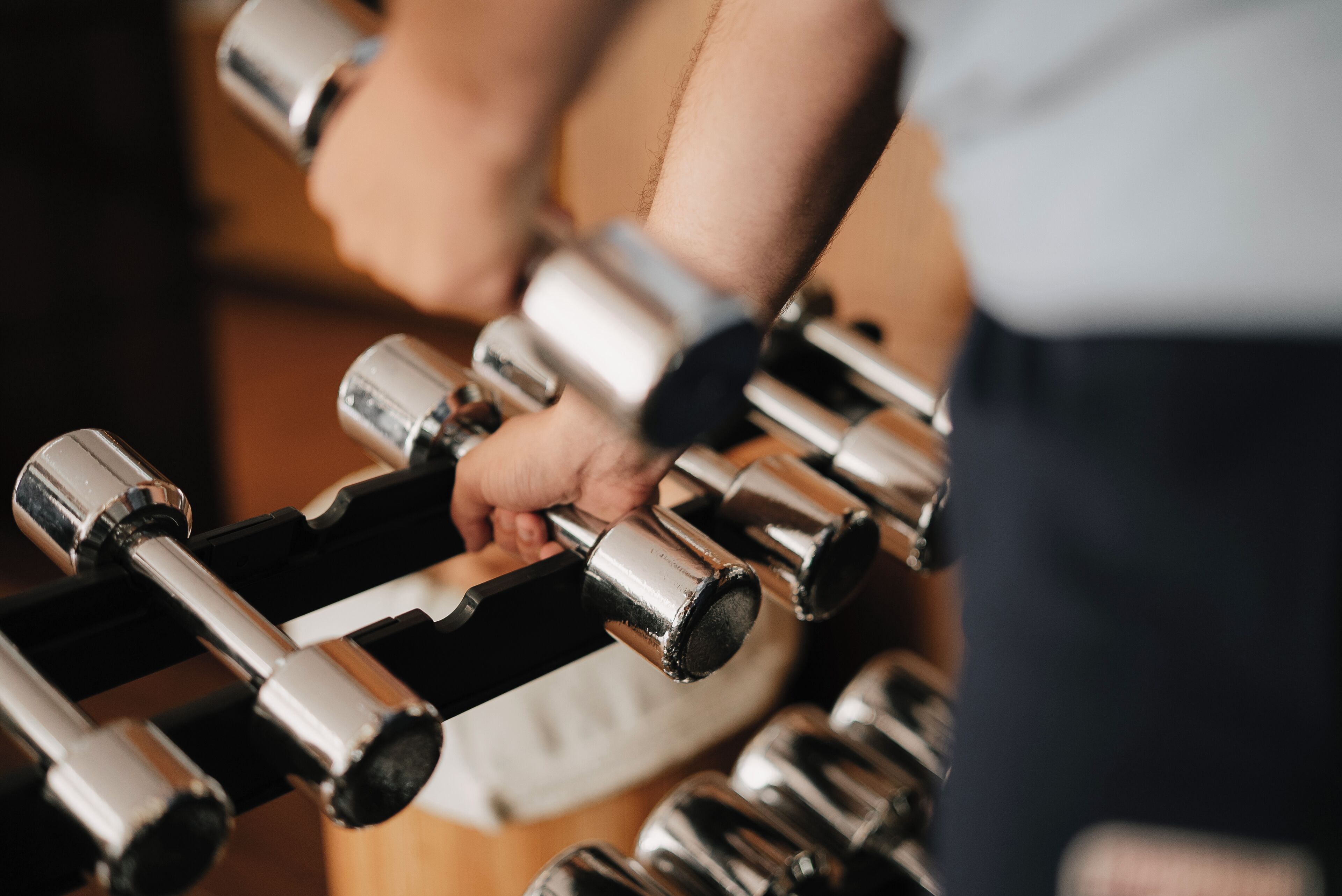 A close-up of a person's hand gripping a dumbbell.