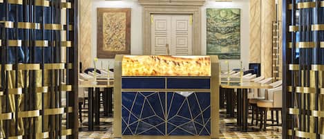 A lobby with a reception desk, seating area, and artwork on the walls.