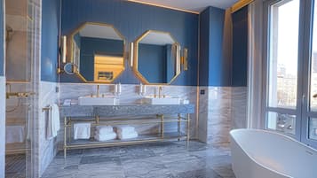 A modern bathroom with two sinks, a freestanding bathtub, and a large window.