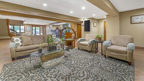 A spacious living area with a beige sofa, two armchairs, a glass coffee table, and a patterned rug. - Best Western Maritime Inn (Sturgeon Bay)