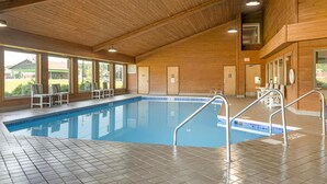 An indoor swimming pool with tiled floors, wooden walls, and large windows. - Best Western Maritime Inn (Sturgeon Bay)