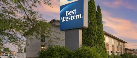 Placa de um hotel Best Western com um edifício moderno ao fundo.