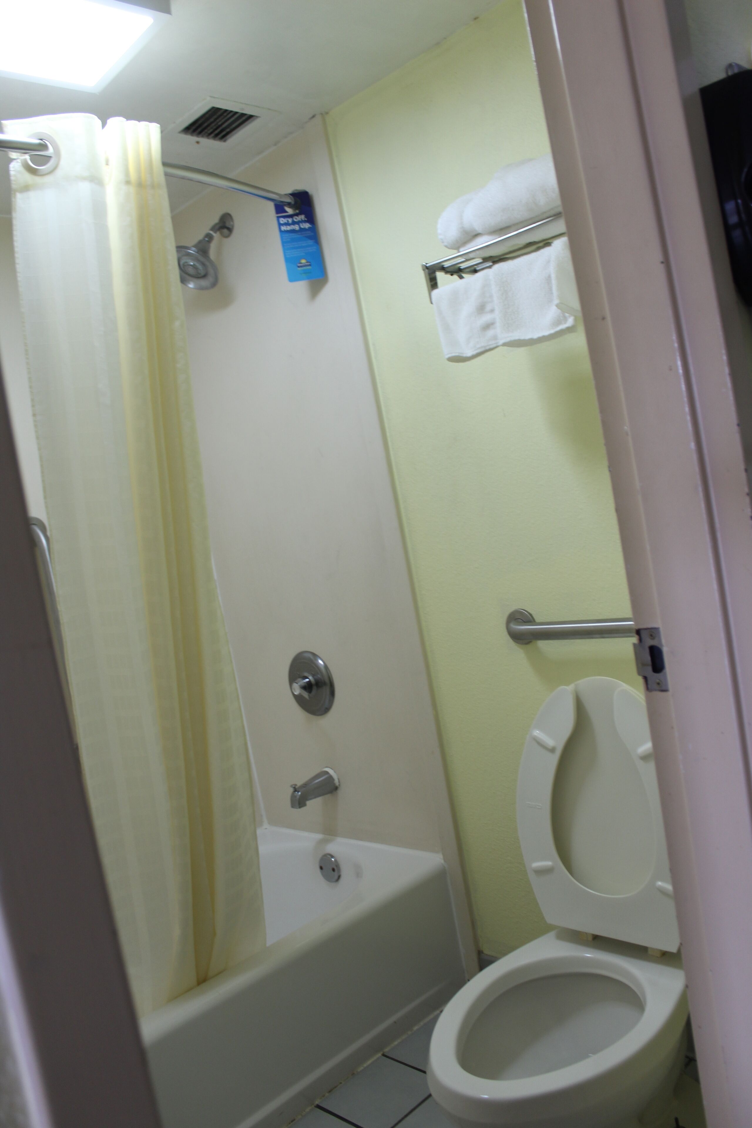 A bathroom with a bathtub, toilet, and a shower curtain.