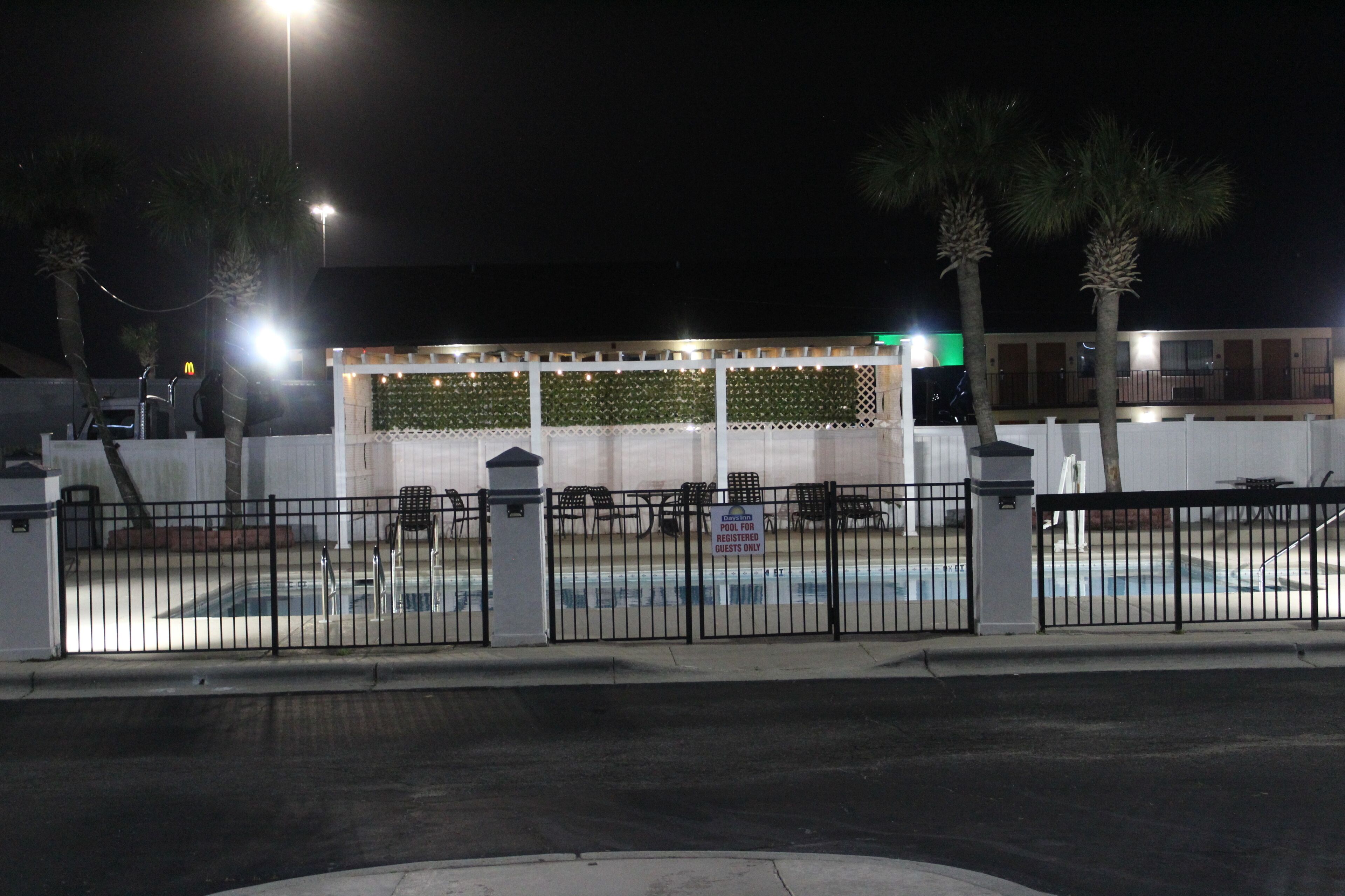 A gated pool area with a sign indicating it is for registered guests only.