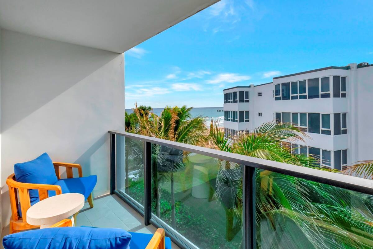 A balcony with a view of a modern building and palm trees.