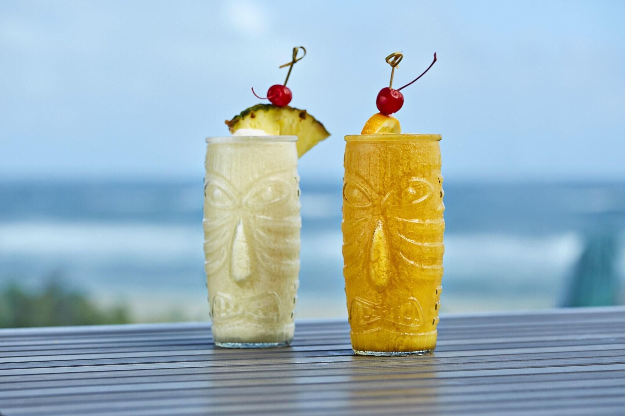 Twee drankjes op een tafel met uitzicht op de oceaan.