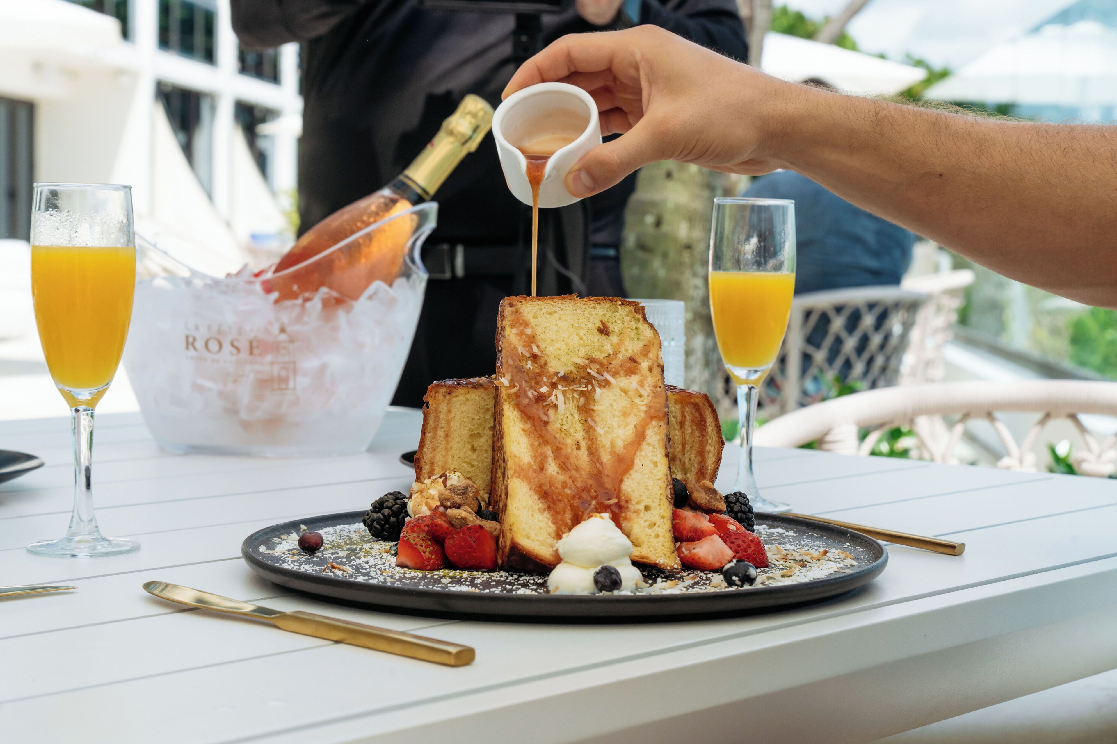 Desayuno con tostadas, fruta y una bebida.