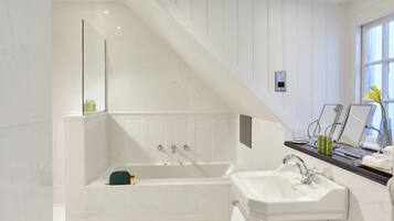 A modern bathroom with a freestanding bathtub, a double sink, and a vanity with a mirror.