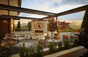 An outdoor patio area with wicker furniture, tables, and a decorative wall. - Randles Hotel Killarney (Killarney)